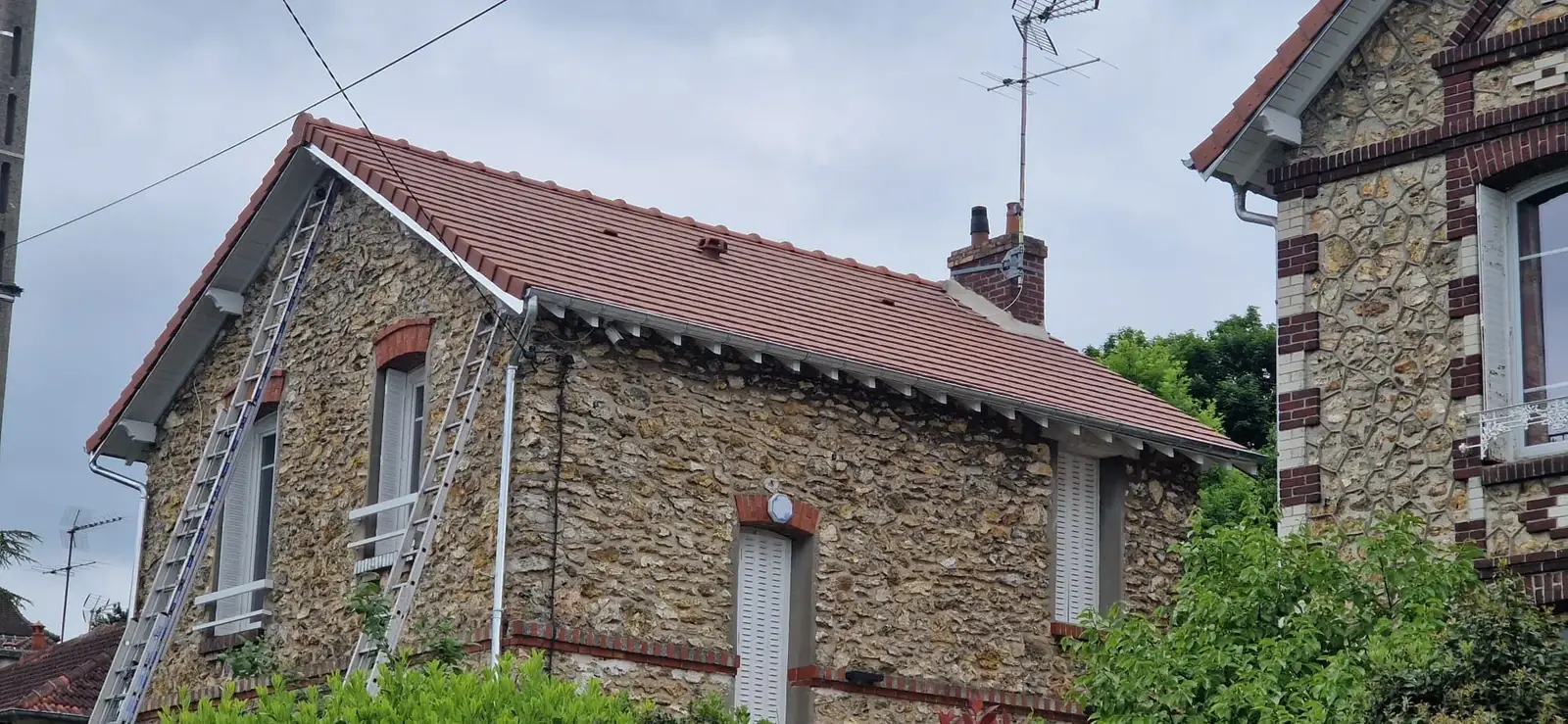 Maison en pierre avec sa toiture en tuiles rénovée